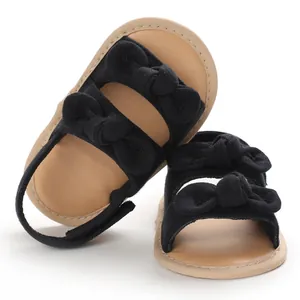 Sandales d'été respirantes pour bébé avec semelles souples et jolis nœuds noirs.