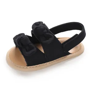 Vue détaillée de sandales de marche noires pour bébé avec nœuds mignons et semelle souple