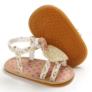 Detail of baby girl summer sandals featuring a gold glitter heart and non-slip sole.