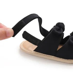 Gros plan sur la fermeture auto-agrippante des sandales de marche noires pour bébé