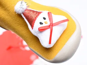 Primer plano del detalle de muñeco de nieve de felpa en calcetines de Navidad para bebé