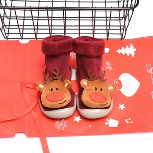 Detailed view of red plush Christmas sock shoes with a cute plush reindeer character