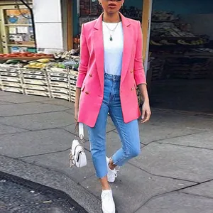 Street style άποψη μιας γυναίκας που φοράει ένα μεσάτο ροζ σακάκι blazer