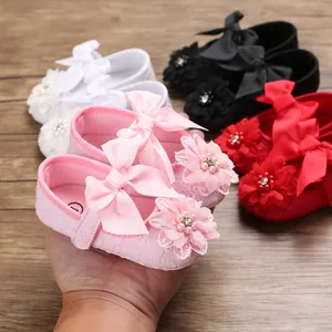 Soft-sole pink baby princess walker shoes with bow and floral lace detail decorations.
