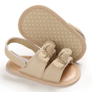 Vue détaillée de sandales de marche beiges pour bébé avec nœuds et semelles souples