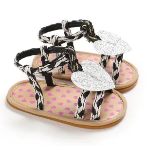 Detailed macro view of baby girl summer sandals with glitter heart and braided straps