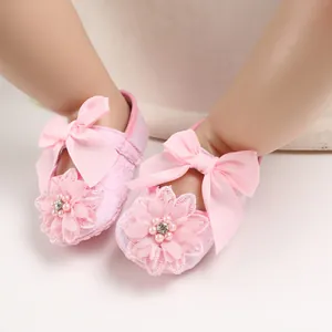 Macro detail view of pink baby princess walker shoes with lace flower and ribbon bow