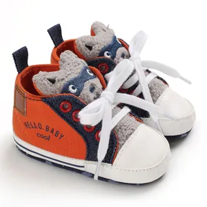 Detail of orange cartoon baby walker shoes with HELLO BABY text and white laces