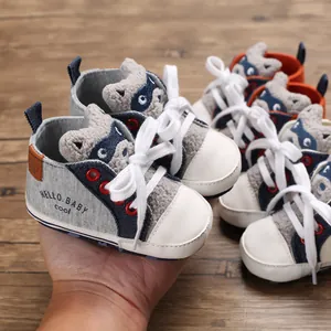 Detailed view of grey cartoon raccoon baby walking shoes with white laces.