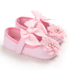 Close-up of pink baby girl princess shoes with decorative flower and bow detail