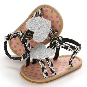 Close-up of baby girl walker sandals featuring silver glitter hearts and braided straps