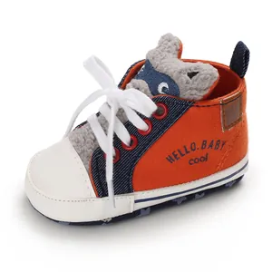 Close-up of cute orange baby walker shoes featuring a cartoon raccoon and soft soles