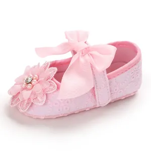 Detailed macro view of a pink lace baby princess walking shoe with silk bow decoration