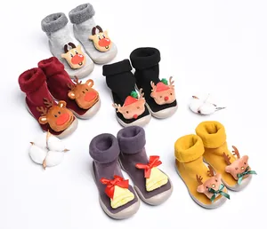 Collection of Christmas-themed baby sock shoes with plush reindeer and bell designs.
