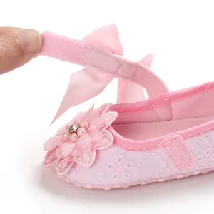 Macro close-up of pink lace infant princess shoe with floral detail and Velcro strap