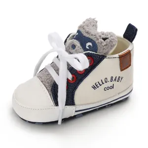 Detailed view of cute cartoon animal plush tongue on white baby canvas pre-walker shoes