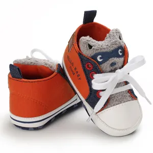 Close-up of baby walker shoes with cute raccoon character and soft canvas texture