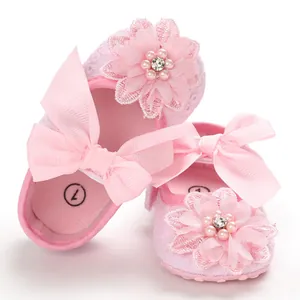 Detailed view of pink baby princess shoes featuring lace floral pearls and bow decorations