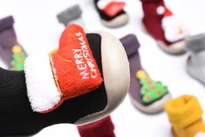 Primer plano de zapatos navideños para bebés con detalle de calcetín de peluche rojo