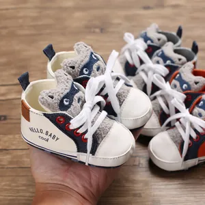 Close-up of soft-soled baby walking shoe with cute bear detail and lace-up design