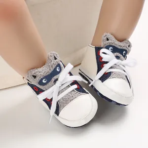 Close-up detail of cartoon raccoon baby walking shoes with soft soles and white laces.