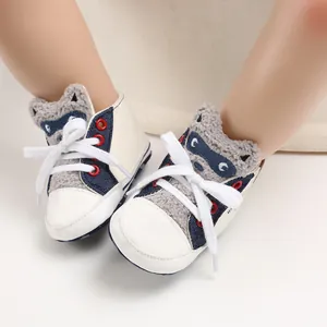 Close-up of baby walking shoes featuring grey raccoon cartoon design and classic white laces