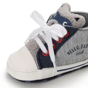 Close-up of soft grey fabric baby walker shoe with laces and cartoon ears