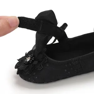 Close-up macro detail of a black baby walking shoe with a functional velcro strap