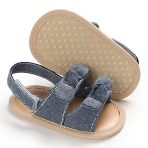 Vue détaillée de sandales bébé en denim bleu avec semelles souples et nœud décoratif