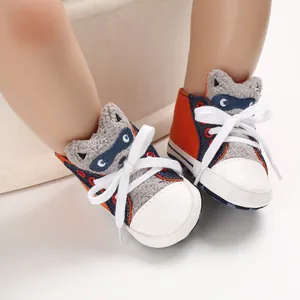 Nahaufnahme von Lauflernschuhen für Babys mit süßem Waschbär-Design und weicher Sohle