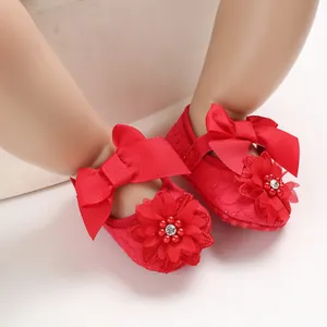 Macro view of red baby princess shoes featuring 3D flower and elegant satin bow decoration
