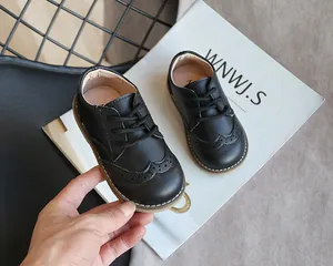 Close-up of classic black brogue shoes for toddlers with intricate hole patterns