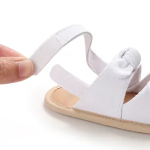Détail macro d'une sandale blanche pour bébé avec fermeture à scratch velcro sécurisée