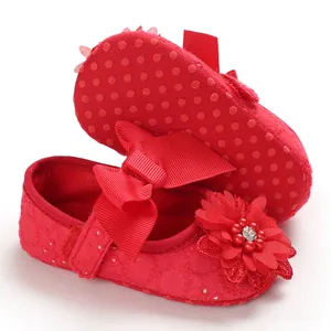 Detailed macro shot of red baby walking shoes with ribbon bow and floral decoration