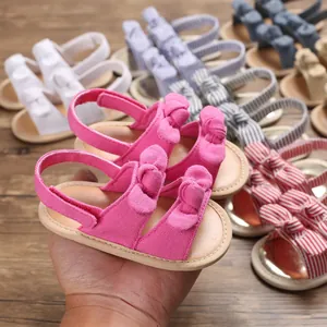 Détail des sandales roses pour bébé avec nœuds et velcro dans plusieurs coloris variés.