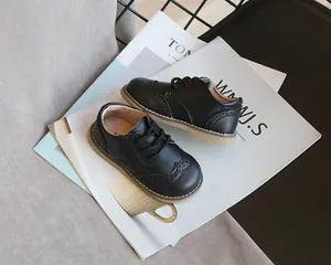 Close-up of elegant children's black leather brogue shoes on a lifestyle background