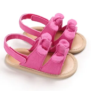 Jolies sandales roses pour bébés avec double nœud et semelles souples et respirantes.
