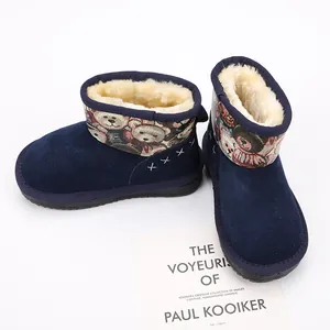 Close-up of children's navy blue snow boots with warm fur lining and teddy bear pattern