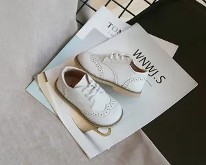 Detailed view of white children's brogue shoes with elegant decorative perforations