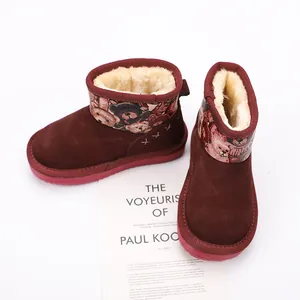 Close-up of children's warm snow boots with teddy bear pattern and cozy faux fur lining.
