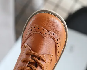 Close-up of brown leather children's shoe featuring classic Brogue wingtip detailing