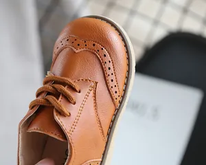 Detailed macro view of brown leather boys brogue shoes with classic wingtip perforations