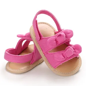 Sandales roses pour bébés avec de jolis doubles nœuds et des semelles souples beiges d'été