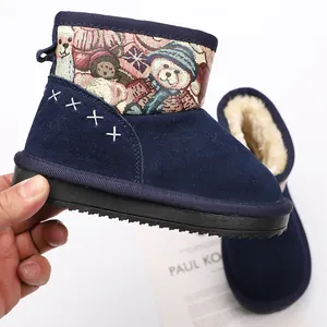 Detailed macro view of blue children's snow boots with cartoon bear print and warm lining