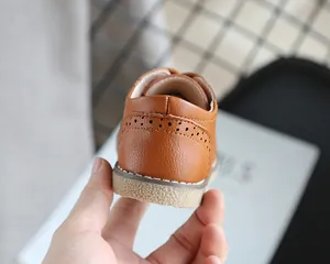 Close-up of brown children's brogue shoes showing heel stitching and texture