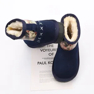 Close-up detail of navy blue children's snow boots featuring a cozy cream faux fur lining