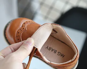 Close-up detail of soft brown leather children's shoe showing breathable interior