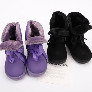 Detailed view of the warm plush lining and silk ribbon bow on children snow boots