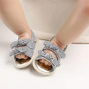 Vue détaillée de sandales pour bébés à semelle souple avec nœuds rayés pour l'été.