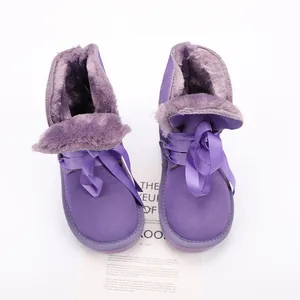 Detailed view of purple children's snow boots with warm plush lining and stylish ribbon bows
